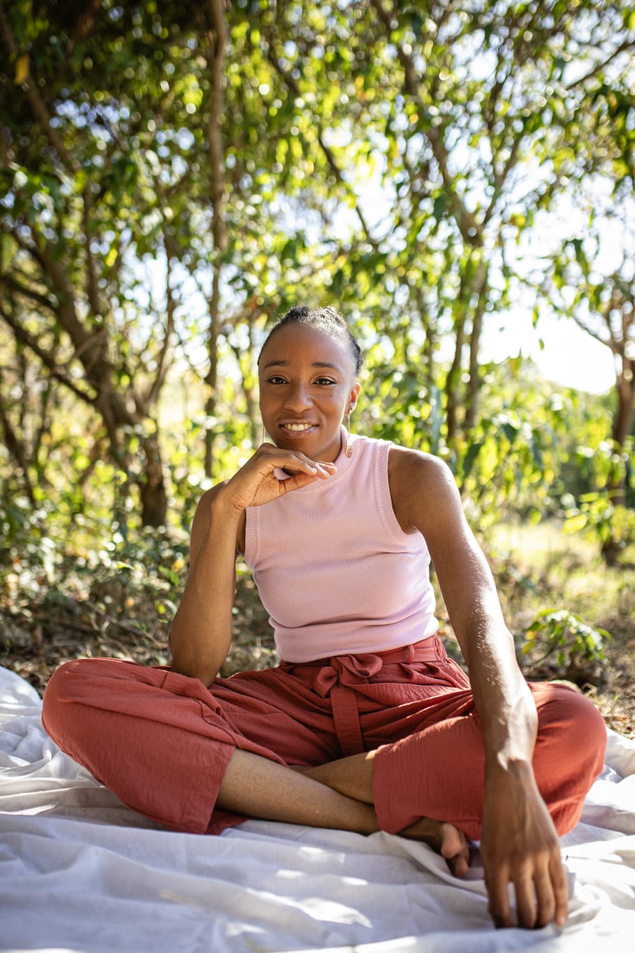 Axelle Célina, infirmière naturopathe, en tailleur rose, souriante et bienveillante en Guadeloupe — soin endo massage et confort menstruel dédié à l'endométriose